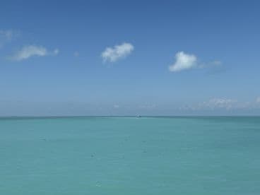 A serene view of turquoise waters under a clear blue sky, capturing the essence of a tranquil day at sea.
