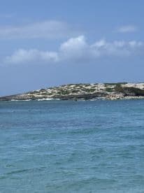 A distant view of an island surrounded by turquoise waters, though the image lacks clarity.