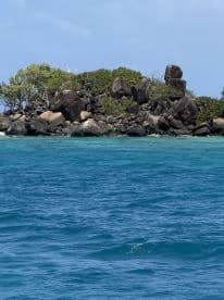 A picturesque view of a rocky island surrounded by vibrant turquoise waters, perfect for exploring and enjoying nature's beauty.