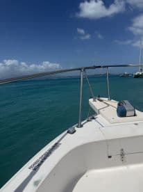 A clear view of the front deck of a boat, showcasing the tranquil turquoise waters and blue sky — perfect for a day of adventure on the water.