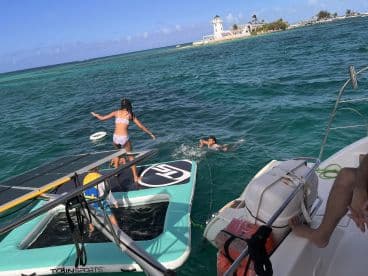 Children enjoy a fun day in the water, with one swimming and another preparing to jump from the boat — a perfect scene for family adventures on the water.