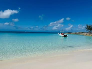 A serene view of a speedboat anchored in crystal-clear waters, showcasing the beauty of a tropical paradise.
