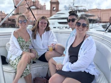 A group of friends enjoys drinks and laughter aboard a boat, capturing the essence of a fun day on the water.