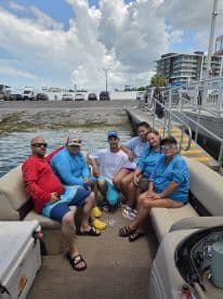 A cheerful group of friends enjoys their time aboard a boat, capturing the essence of a fun day on the water with laughter and camaraderie.