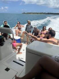 A lively group enjoys a sunny day on a boat, capturing the essence of fun and celebration on the water.
