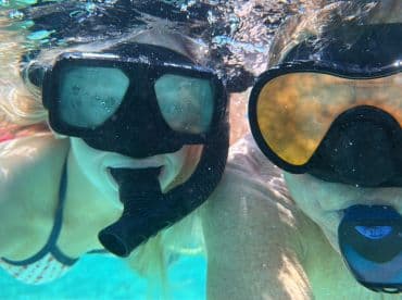 Two snorkelers enjoy an underwater adventure, capturing the excitement of exploring marine life — a perfect highlight of any boating trip.