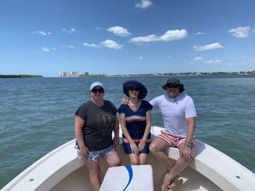A cheerful group of friends enjoys a sunny day on the boat, perfect for creating lasting memories on the water.
