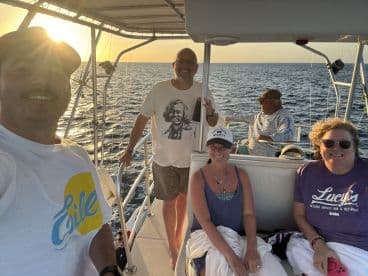 A cheerful group enjoys a sunset boat trip, capturing the joy of friendship on the water. Perfect for memorable outings and celebrations.