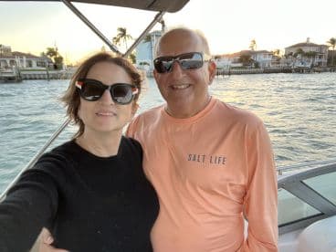 A couple enjoys a picturesque sunset on a boat, capturing a memorable moment together — perfect for romantic outings or special celebrations on the water.