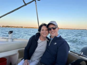 A happy couple enjoys a scenic boat ride, capturing a moment of joy and connection on the water — perfect for romantic outings or sunset cruises.