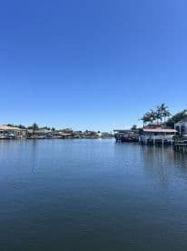 A scenic view of a calm waterway lined with homes and palm trees, perfect for boating enthusiasts.