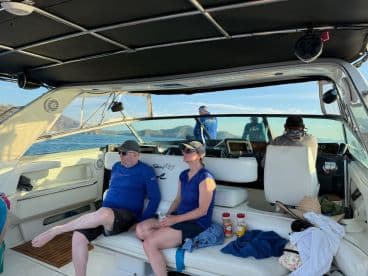 A cozy interior view of a Sea Ray boat featuring guests relaxing on the seating area, showcasing the helm and cabin space — perfect for leisurely outings on the water.