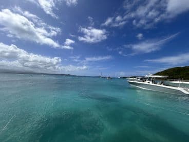 A stunning view of a sleek boat cruising through crystal-clear turquoise waters, surrounded by a picturesque landscape — perfect for showcasing boating adventures.