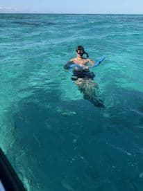 A snorkeler enjoys the vibrant turquoise waters, showcasing the perfect setting for underwater exploration and aquatic adventures.