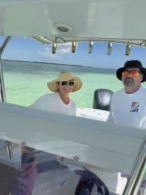 A cheerful couple enjoys a sunny day on the water, showcasing the perfect boating experience. Ideal for those looking to relax and explore the beautiful surroundings.