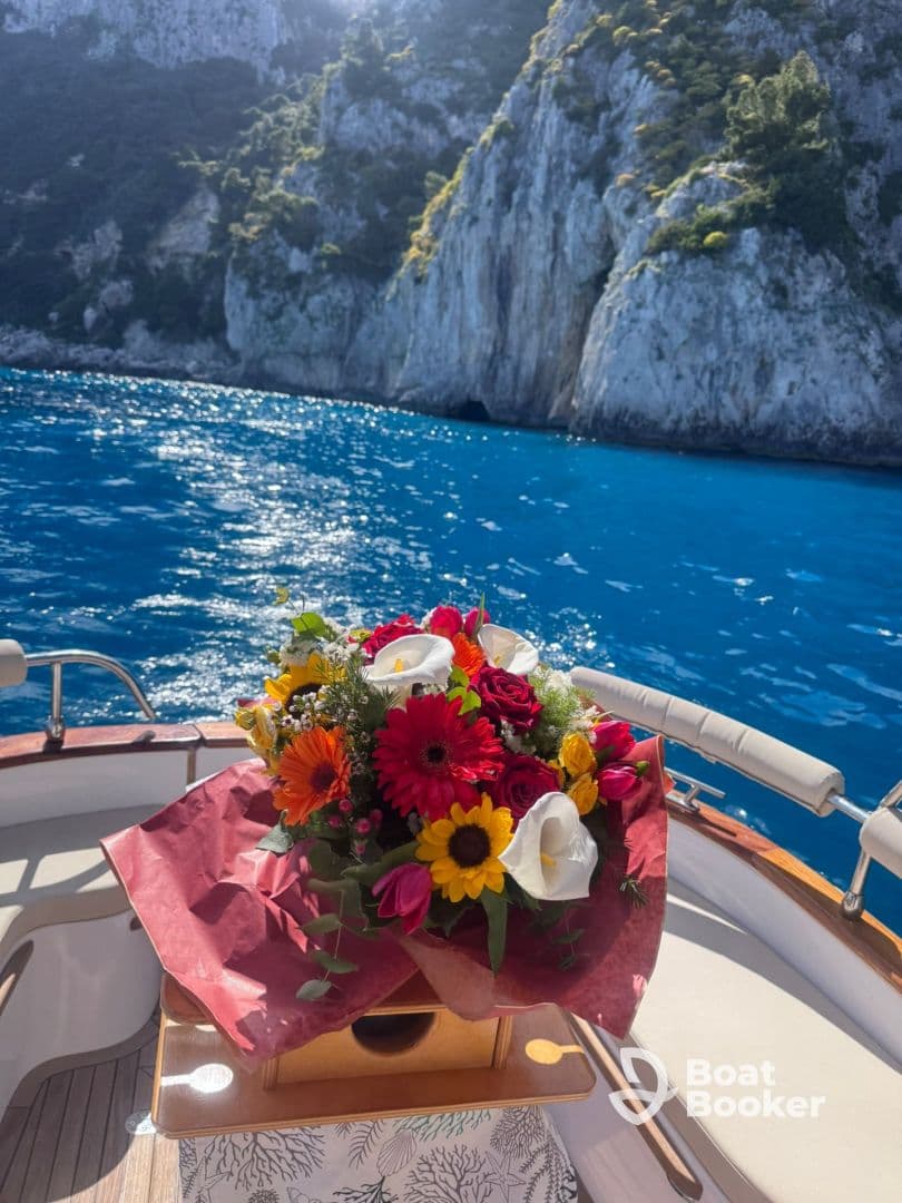 A beautiful bouquet of flowers displayed on a boat, adding a touch of elegance to the maritime experience against a stunning coastal backdrop.