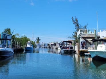 A serene view of boats docked along a tranquil waterway, showcasing the beauty of waterfront living and boating in a picturesque setting.