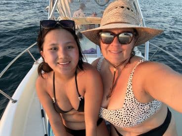 A mother and daughter enjoy a sunny day on the boat, capturing a joyful moment together — perfect for family outings and memorable adventures on the water.