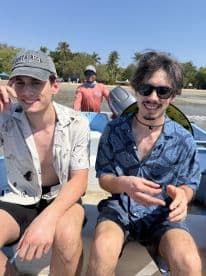 Two friends enjoy a sunny day on a boat in Costa Rica, capturing the essence of adventure and camaraderie on the water.
