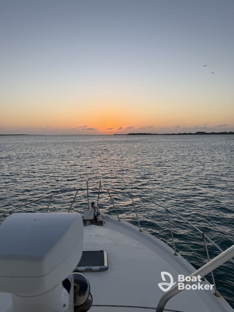 A serene view from the bow of a boat at sunset, showcasing the tranquil waters and the horizon — perfect for peaceful evening cruises.