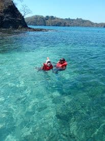 Two snorkelers enjoy the clear waters while exploring the vibrant marine life, making for an unforgettable underwater adventure.