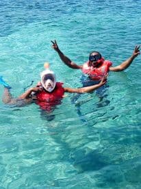 Two snorkelers enjoy a vibrant underwater adventure, showcasing the fun of swimming in crystal-clear waters — perfect for family outings and aquatic exploration.