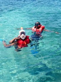 Two snorkelers enjoy the vibrant underwater world in crystal-clear waters, showcasing the excitement of marine adventures.