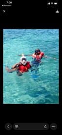 Two individuals enjoy snorkeling in crystal-clear waters, showcasing the fun and adventure of underwater exploration.