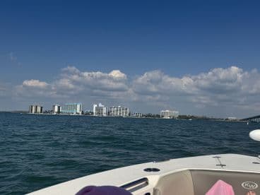 A scenic view of waterfront buildings against a clear blue sky, captured from a boat, showcasing the beauty of coastal landscapes.