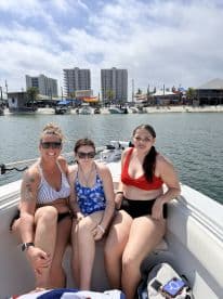 A group of three women relaxes on the boat, enjoying a sunny day on the water — perfect for family outings and summer adventures.