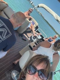 A lively group enjoys a relaxing day on a pontoon boat, soaking up the sun and enjoying the beautiful waters — perfect for a fun day out on the water.