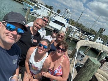 A cheerful group poses for a selfie at the dock, ready for a fun day on the water — perfect for celebrations and group outings.