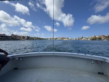 A scenic view from the bow of a boat cruising through a picturesque waterway lined with beautiful homes, showcasing the charm of waterfront living.