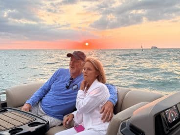 A couple enjoys a romantic sunset view from their boat, creating a perfect backdrop for special moments on the water.