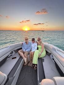 A group of friends enjoys a stunning sunset aboard a boat, capturing the perfect moment for a memorable outing on the water.