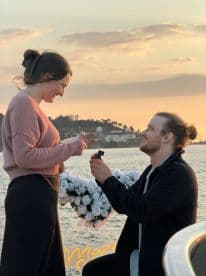 A romantic sunset proposal on a boat, capturing a couple's special moment surrounded by beautiful flowers — perfect for unforgettable engagements.