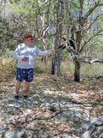 A man interacts with a monkey in a lush natural setting, showcasing a unique wildlife encounter in the wild.