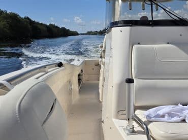 A view of the interior seating and helm area of a boat, showcasing a clean and spacious design perfect for comfortable cruising.