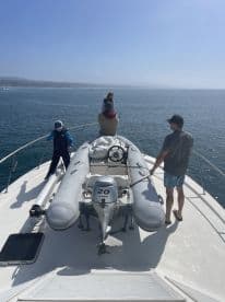 A family enjoys a sunny day on the boat, with children exploring and taking in the ocean views — perfect for memorable outings on the water.