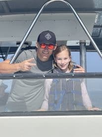 A joyful moment captured with an adult and a child on a boat, showcasing family fun and bonding on the water.