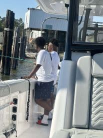 Two children enjoy a fishing trip on a boat, showcasing the joy of outdoor activities and family bonding on the water.