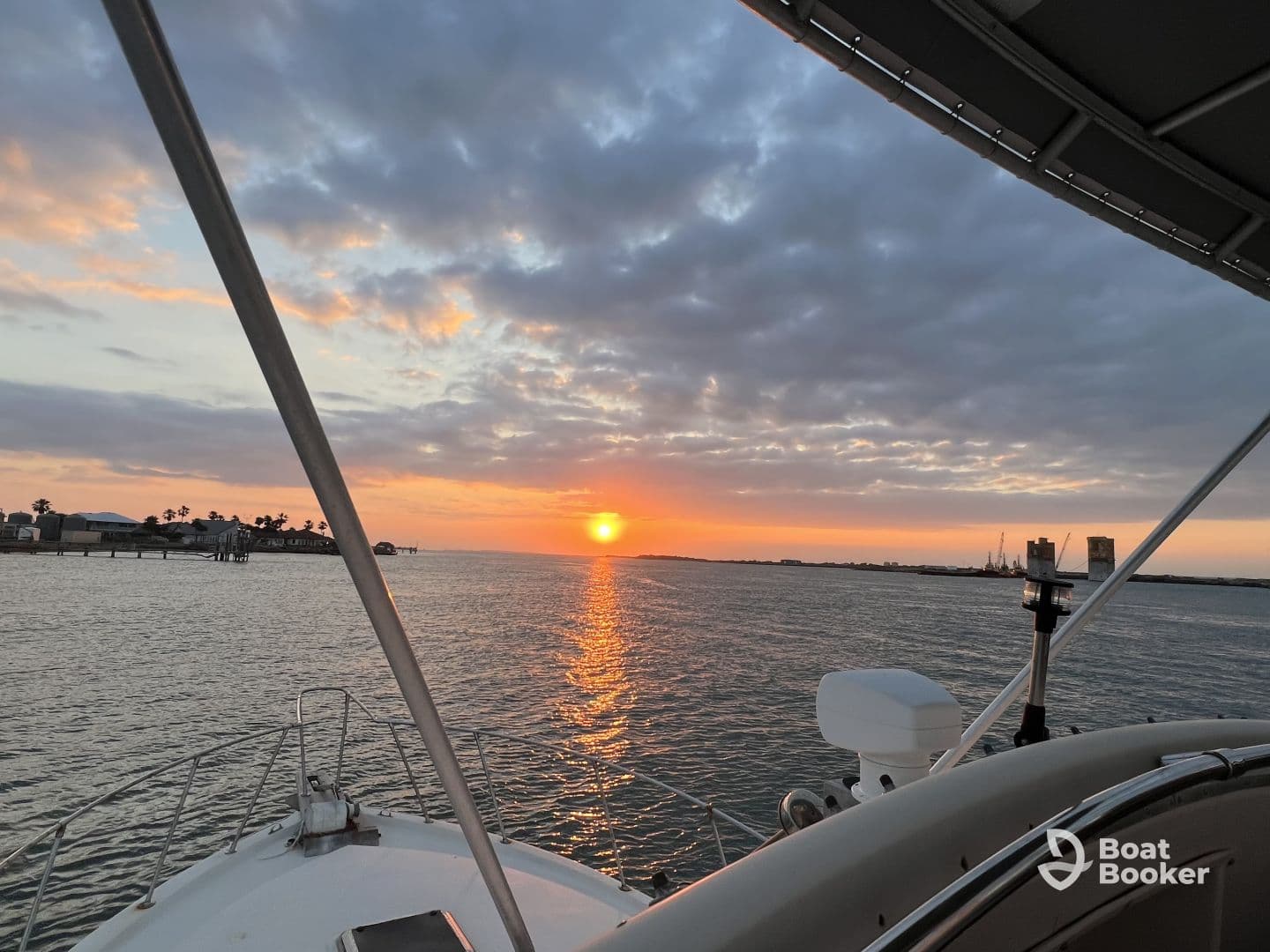 A serene sunset view from the bow of a boat, showcasing the tranquil waters and distant shoreline, perfect for evening cruises.