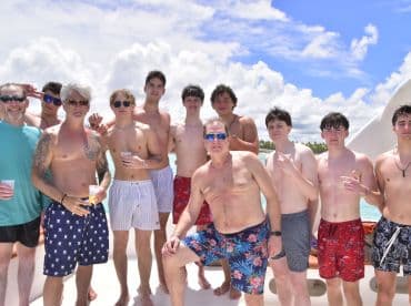 A lively group of young men enjoys a fun day on the water, celebrating together under the sun — perfect for summer adventures and memorable outings.