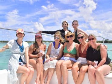 A joyful group of friends poses together on a boat, enjoying a sunny day on the water — perfect for celebrations and memorable outings.