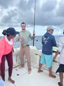 A group of friends enjoys a fishing trip on the ocean, showcasing their catch and the excitement of the day.
