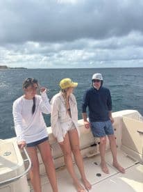 A group of friends enjoys a day on the boat, soaking in the ocean views and good company under a cloudy sky.