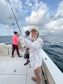 A joyful group enjoys a fishing trip on the ocean, with one angler proudly displaying their catch. Perfect for adventure seekers and fishing enthusiasts.