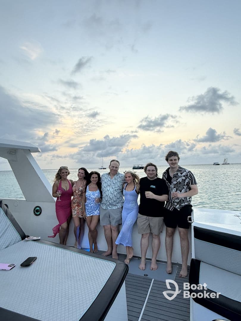 A joyful group of friends celebrates together on a yacht at sunset, capturing the essence of a perfect evening on the water.