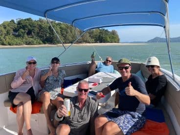 A cheerful group enjoys a sunny day on the boat, celebrating with drinks and good company — perfect for a memorable outing on the water.