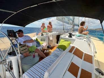 A group enjoys a relaxing day sailing on the open water, capturing the essence of leisure and camaraderie aboard the boat.